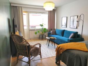 a living room with a blue couch and a bed at City Apartment Savonkatu in Kuopio
