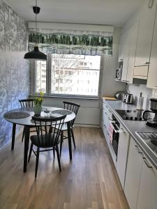 City Apartment Savonkatu في كوبيو: مطبخ مع طاولة وكراسي ونافذة