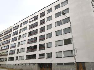 a white building with a street light in front of it at City Apartment Savonkatu in Kuopio