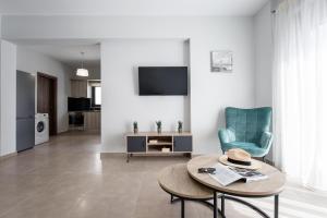 a living room with a table and a blue chair at Casa Ntore Luxury Apartments in Chania Town