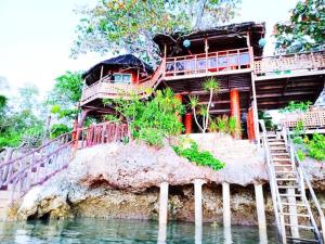 Sun & Sea Home Stay في جزر كاموتيس: منزل فوق صخرة في الماء