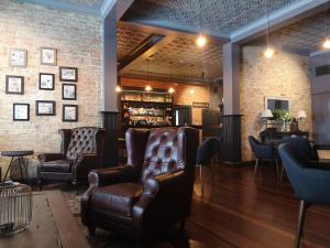 um bar com cadeiras de couro e um balcão de bar em CocoBrew Boutique Apartments em Rockhampton