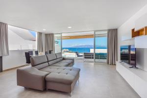 ein Wohnzimmer mit einem Sofa und Meerblick in der Unterkunft Magnífico Bungalow con Vista Panorámica y Piscina Privada in Acantilado de los Gigantes