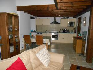 a living room with a couch and a kitchen at Coutancie in Nanteuil-de-Bourzac