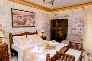 a bedroom with a bed and a table and a chair at D & Sons Apartments in Kotor