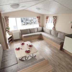 a living room with a couch and a table at Camping De Binnenvaart Superior Chalet in Houthalen-Helchteren