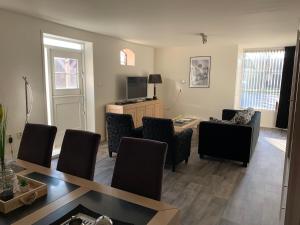 ein Wohnzimmer mit Tisch und Stühlen in der Unterkunft appartement het Stolpje in Julianadorp