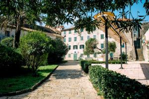 a brick path in front of a white building at D & Sons Apartments in Kotor