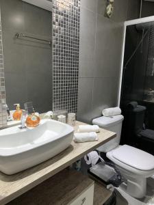 a bathroom with a sink and a toilet at Mello's House in Curitiba