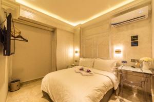 a bedroom with a white bed and a sink at AC Residence - Behind Cititel Hotel in Kota Kinabalu