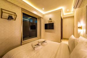 a bedroom with a large white bed with a window at AC Residence - Behind Cititel Hotel in Kota Kinabalu