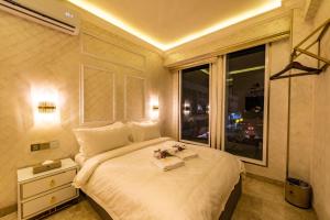 a bedroom with a large white bed with a window at AC Residence - Behind Cititel Hotel in Kota Kinabalu