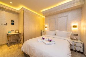 a bedroom with a large white bed and a desk at AC Residence - Behind Cititel Hotel in Kota Kinabalu
