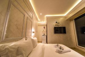 a bedroom with a bed with white sheets and a window at AC Residence - Behind Cititel Hotel in Kota Kinabalu