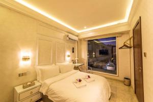 ein Schlafzimmer mit einem weißen Bett und einem Fenster in der Unterkunft AC Residence - Behind Cititel Hotel in Kota Kinabalu