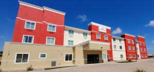 un gran edificio rojo y blanco en una calle en Hawthorn Suites by Wyndham San Angelo, en San Angelo