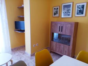 a living room with a tv and a entertainment center at Apartamentos Querol in Valderrobres