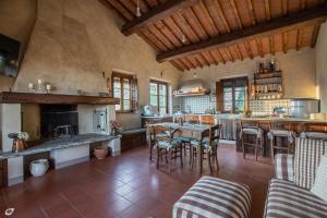 eine große Küche mit einem Tisch und Stühlen in der Unterkunft Villa Jasmine con vista mare e piscina in Corsanico-Bargecchia