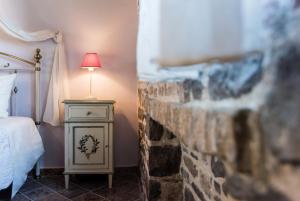 a bedroom with a bed and a stone fireplace at Palaeopoli Villas in Avlemonas