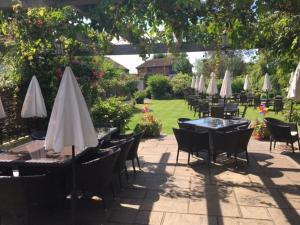 a group of tables and chairs with white umbrellas at The Three Cups Inn in Stockbridge