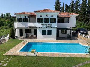 a house with a swimming pool in front of it at Horto Bay Studios in Chorto