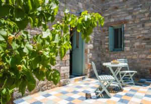 a patio with a table and chairs in front of a building at Palaeopoli Villas in Avlemonas