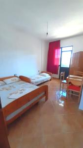 - une chambre avec 2 lits, une table et des chaises dans l'établissement Vila Flamuri, à Golem