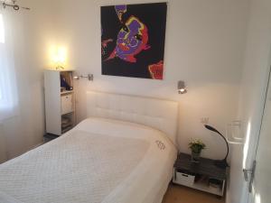 un pequeño dormitorio con una cama y una pintura en la pared en Résidence Chantemerle, en Cannes