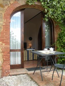 a table and chairs on a patio with a window at Fattoria del Colle in Trequanda
