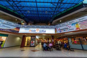 a shopping mall with people sitting in chairs in it at AC Residence - Behind Cititel Hotel in Kota Kinabalu