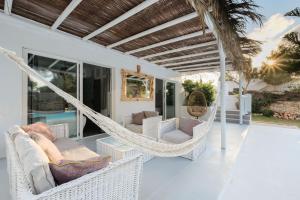 a porch with a hammock and chairs on a house at Villa Clara Ibiza in Santa Eularia des Riu