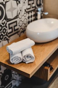 ein Stapel Handtücher auf einem Tisch neben einem Waschbecken in der Unterkunft 3in1 Holiday Home in Rogoznica + 113 Fotos