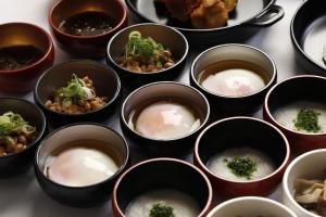 Dormy Inn Premium Shimonoseki في شيمونوسيكي: مجموعة من الأطباق مليئة بالطعام على طاولة