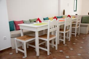 a white table and chairs with a couch in the background at Costa Marina Villas in Fira