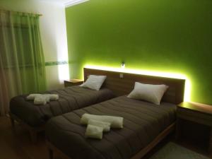 two beds in a room with green walls at Casa da Floresta in Santiago da Guarda