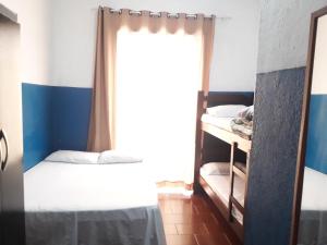 a bedroom with two bunk beds and a window at Pousada das Goianas in Santos
