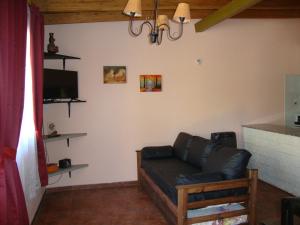 uma sala de estar com um sofá e uma televisão em Los Nietos Departamentos em Mendoza