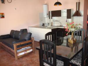 uma sala de estar com um sofá e uma mesa de vidro em Los Nietos Departamentos em Mendoza