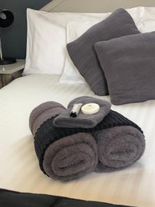 einen Haufen Handtücher und Kissen auf dem Bett in der Unterkunft Inverell Motel in Inverell