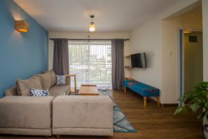 a living room with a couch and a window at Sports Road Apartments by Dunhill Serviced Apartments in Nairobi