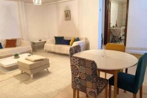 a living room with a table and a couch at Cosy 2 pièces charmant et spacieux in Tunis