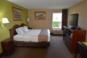a hotel room with a bed and a flat screen tv at Jameson Inn and Suites Hazelhurst in Hazlehurst