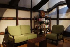 a living room with two chairs and a book shelf at Sumiyoshiya in Kanazawa
