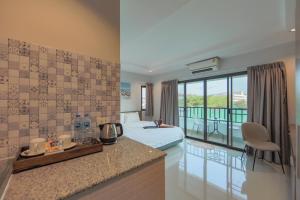 a hotel room with a bed and a kitchen with a view at Nalanta Hotel Pattaya in Pattaya Central