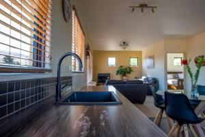 a kitchen with a sink and a living room at Bannockburn House in Cromwell