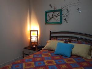 1 dormitorio con 1 cama y 1 mesa con lámpara en Villa de María, en Guayaquil