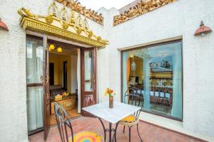 a patio with a table and chairs and a balcony at Baber Mahal Vilas - The Heritage Hotel in Kathmandu