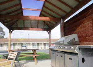 d'une terrasse avec un barbecue et une table de pique-nique. dans l'établissement Golden Palms Motel, à Geelong