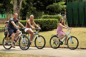 a group of people riding bikes down a sidewalk at Hotel Albatros Plava Laguna in Poreč