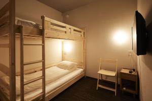 a bedroom with two bunk beds and a chair at HOTEL THE ROCK in Osaka